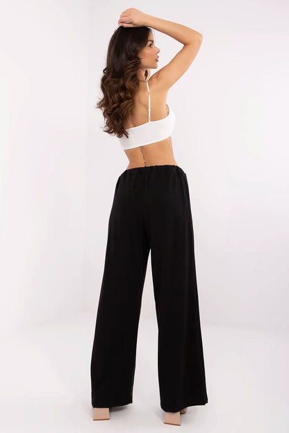 Model presenting the back view of luxury tracksuit trousers in black, highlighting the sleek design and comfortable fit, crafted by Relevance.