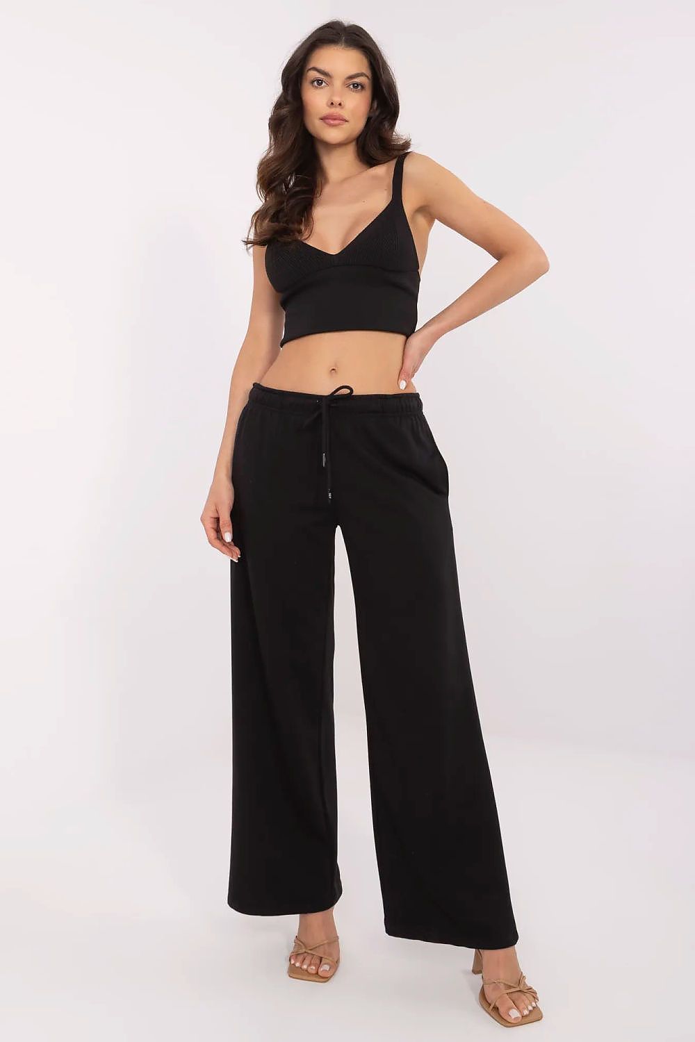 Luxury cotton-blend tracksuit trousers for men and women from Relevance, featuring a comfortable fit, elegant straight leg design, and stylish side pockets, showcased by a model in a black outfit.