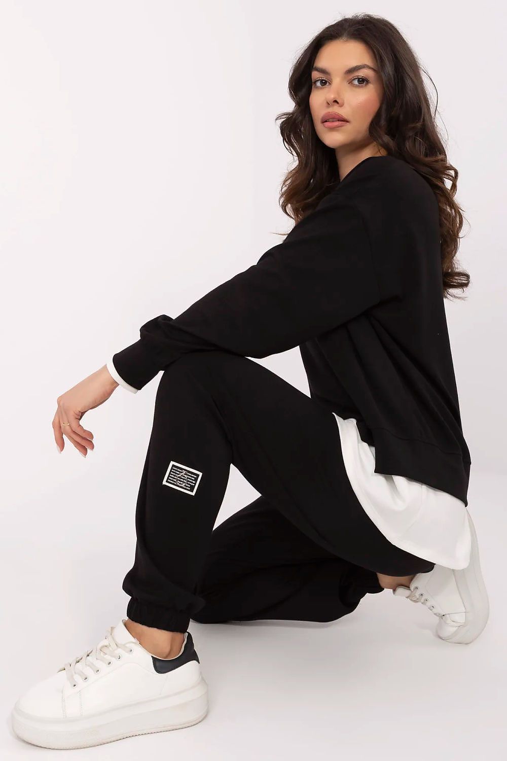 Elegant black women's casual tracksuit set from Relevance, showcasing the soft fabric of the long-sleeve sweatshirt and high-waisted pants, perfect for achieving a modern and chic look.