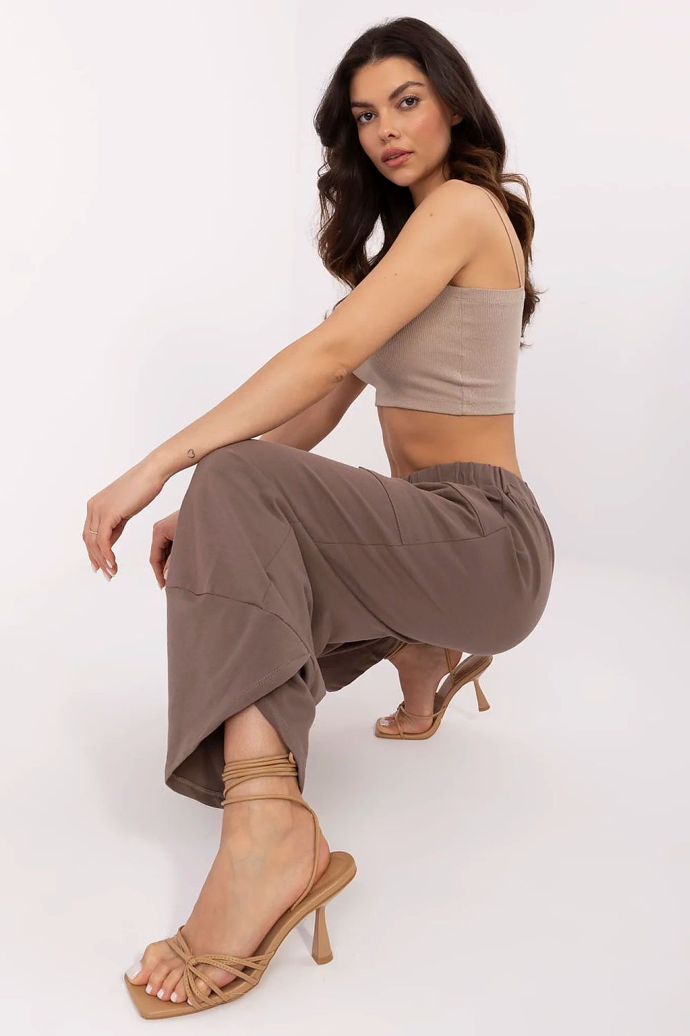 Elegantly styled model showcasing women's Aladdin-style cotton-spandex tracksuit trousers in a soft taupe hue, designed for comfort by Relevance.