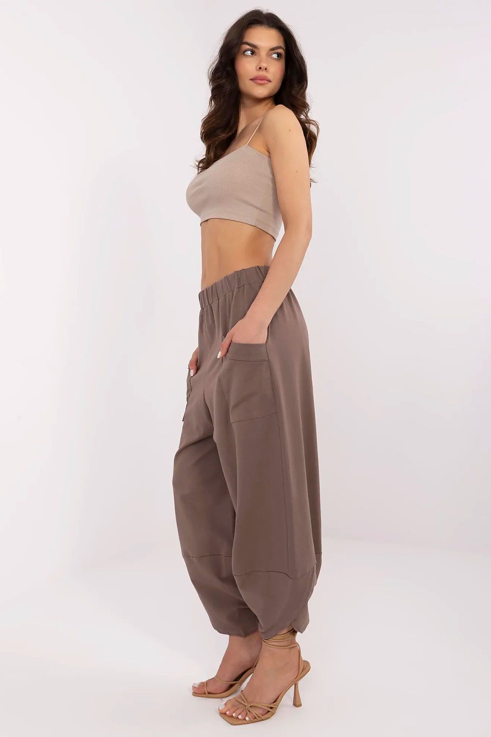 Side view of a model wearing high-waisted Aladdin-style tracksuit trousers with functional pockets, exuding effortless style by Relevance.