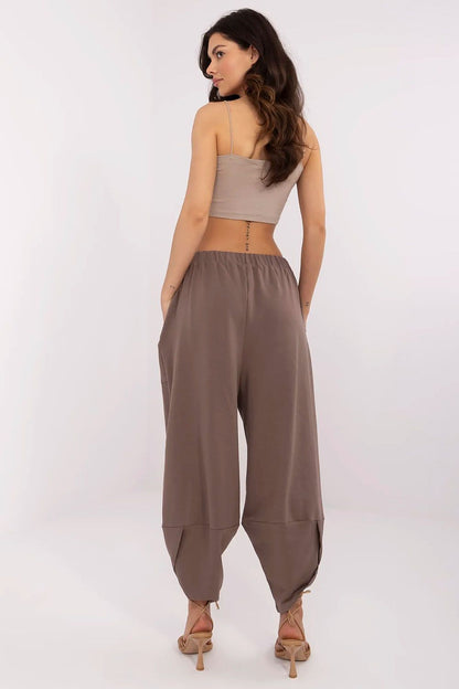 Chic rear view of a model in luxurious Aladdin-style sweatpants, highlighting the relaxed fit and high waist, featuring Relevance branding.