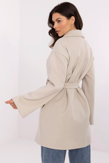 Elegant Och Bella women's transitional coat in cream, featuring a belted waist and flowing sleeves, designed for stylish autumn and winter outings.