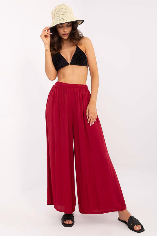 A model showcasing elegant wide-leg viscose trousers in red, by Och Bella. The high-waisted design enhances a fashionable silhouette, perfect for everyday casual style.