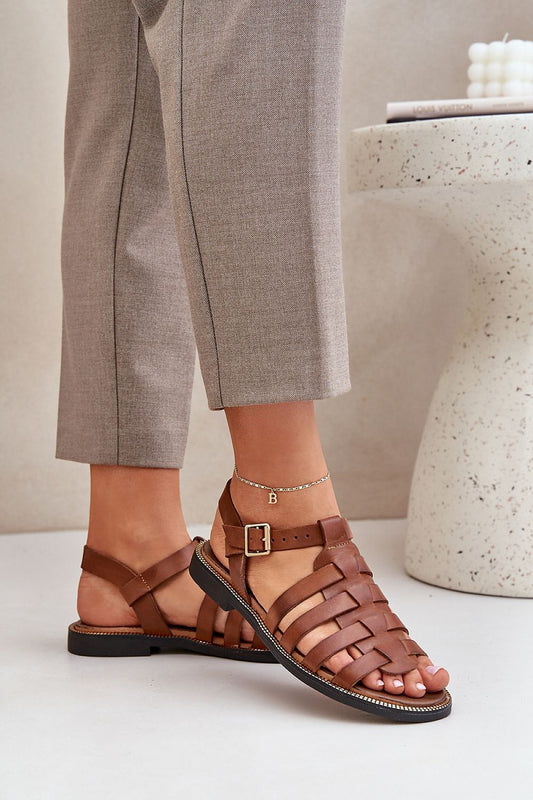 Elegant natural leather sandals by Step in Style featuring an adjustable strap and a flat heel, showcased with stylish trousers.