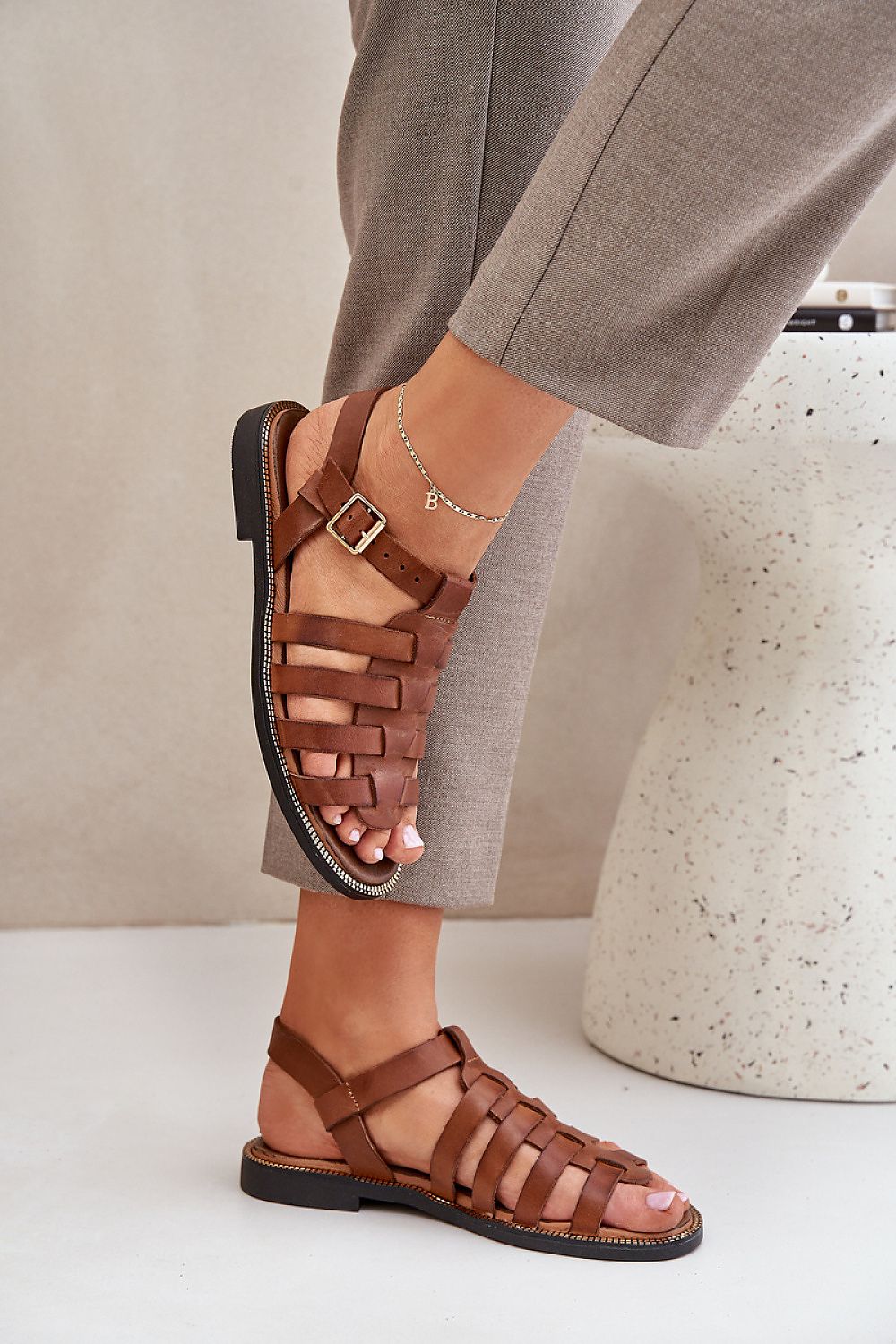 Elegant brown natural leather sandals from Step in Style, featuring an adjustable strap and a stylish woven design, showcased on a model's foot.