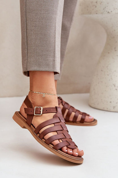 Stylish brown natural leather sandals by Step in Style, highlighted with an adjustable strap and a sleek woven pattern, presented elegantly on a model's foot.