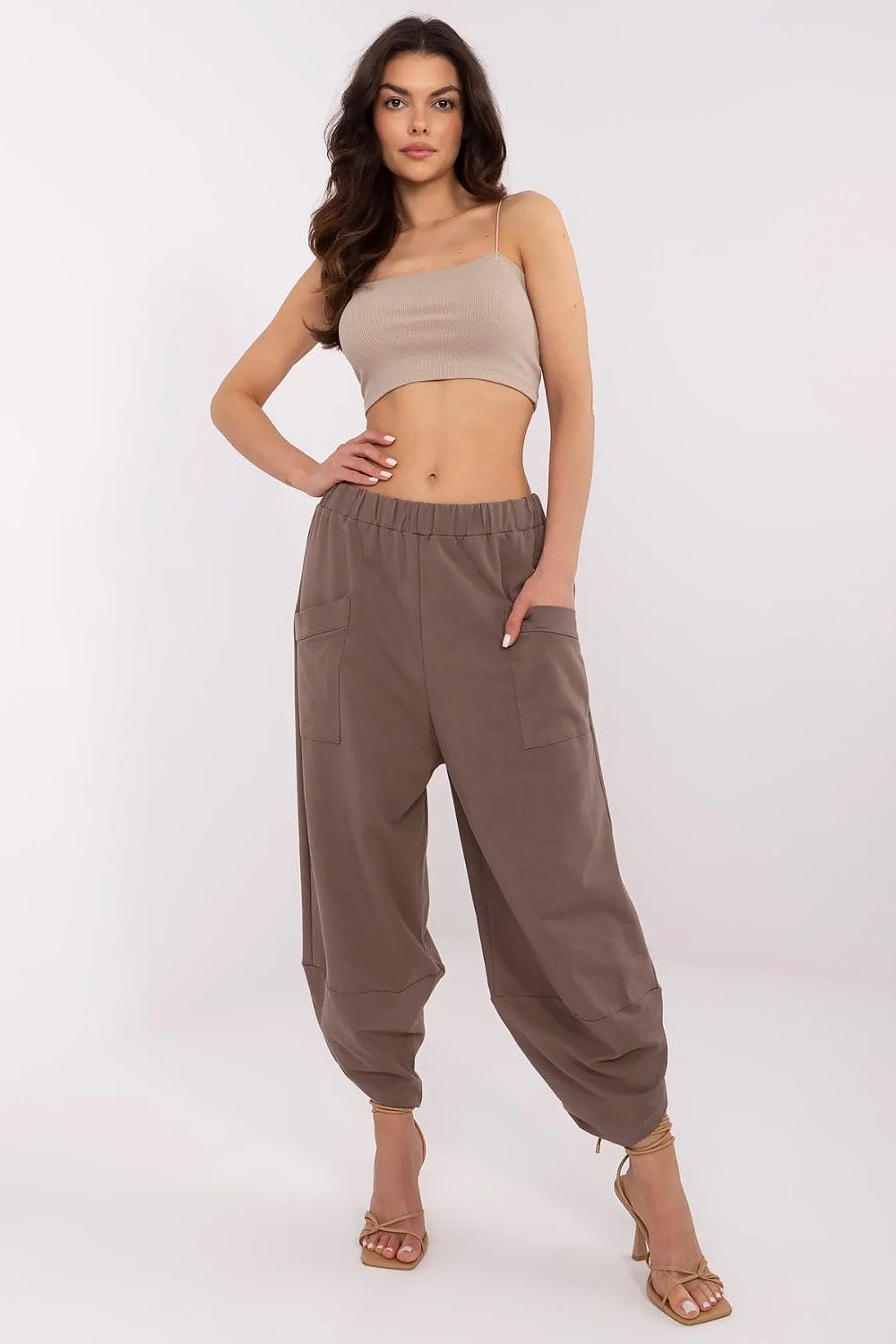 Bold front view of a model confidently wearing Aladdin-style cotton-spandex tracksuit trousers with stylish pockets, a premium design by Relevance.