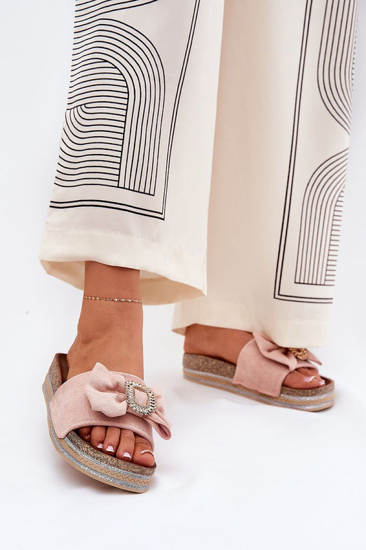 Stylish luxury eco suede flip-flops with a decorative bow and brooch by Step in Style, worn elegantly with a flowy outfit.