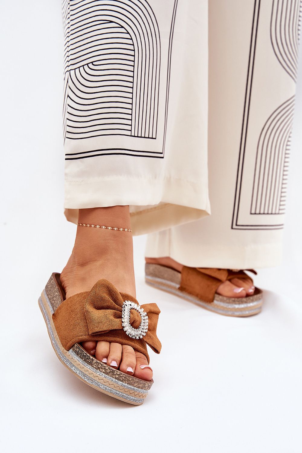 Chic eco suede flip-flops with a stylish bow and brooch in a rich brown tone by Step in Style, perfectly matched with fashionable trousers.