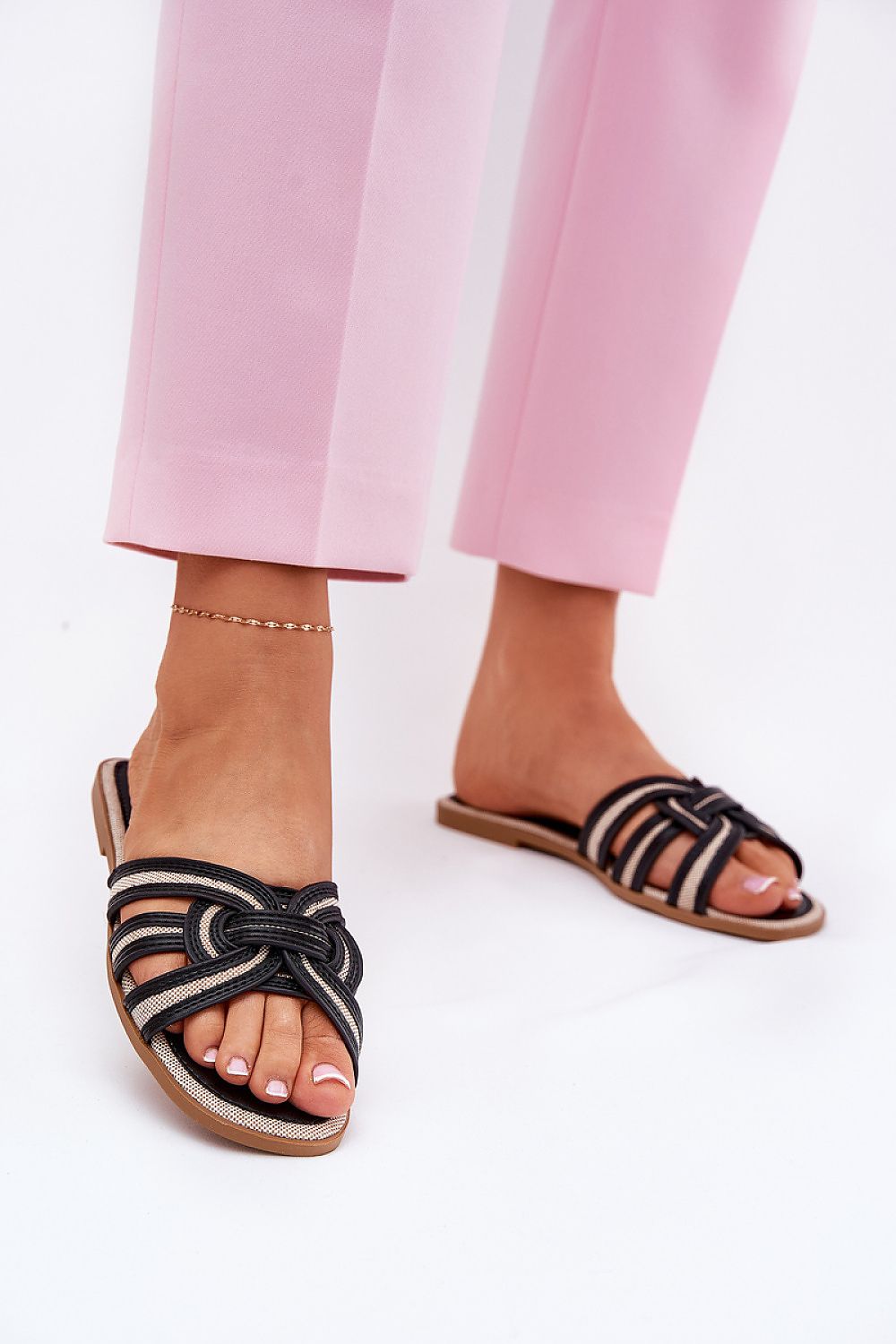 Elegant women's eco leather flip-flops with interwoven straps, styled with pink trousers, perfect for summer fashion. | Step in style