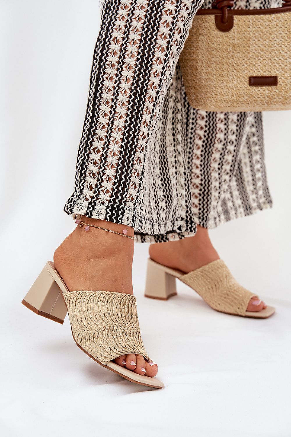 Sophisticated beige women's braid design slippers by Step in Style, paired with stylish patterned trousers, ideal for a summer outing.