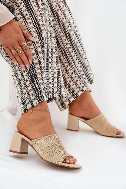 Stunning beige women's slippers by Step in Style, detailed with a unique braid design, elegantly styled with patterned trousers for a fashionable look.