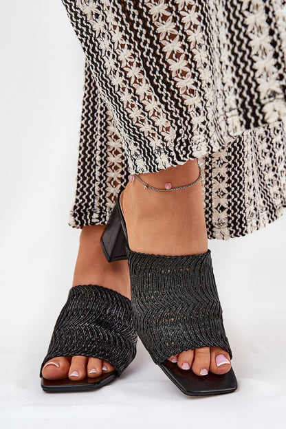 Elegant black women's braid design slippers by Step in Style, showcasing a chic look paired with a flowing patterned maxi dress, perfect for summer outings.