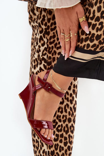 Elegant eco leather wedge sandals in burgundy, showcasing an adjustable ankle buckle, paired with chic leopard print trousers, by Step in style.