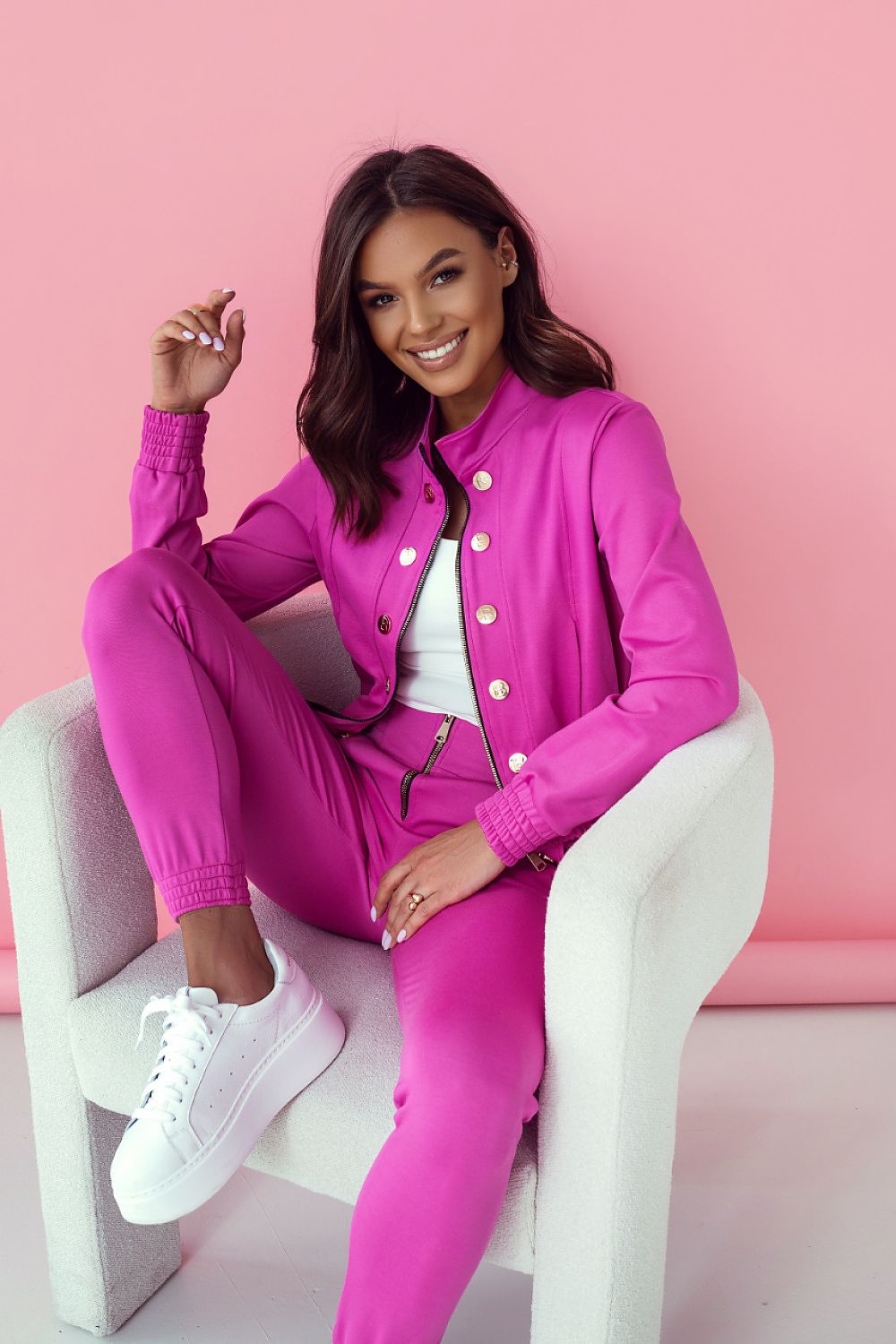 LaBalancia luxury women's pink elegant set featuring long trousers and a stylish blouse, showcased with a smile in a chic modern setting.