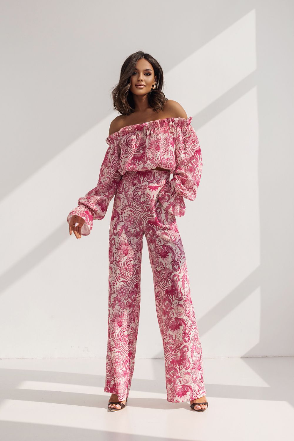 Elegant women's set by LaBalancia featuring a frilled off-shoulder blouse and high-waisted trousers, styled in a vibrant pink floral pattern, perfect for special occasions.