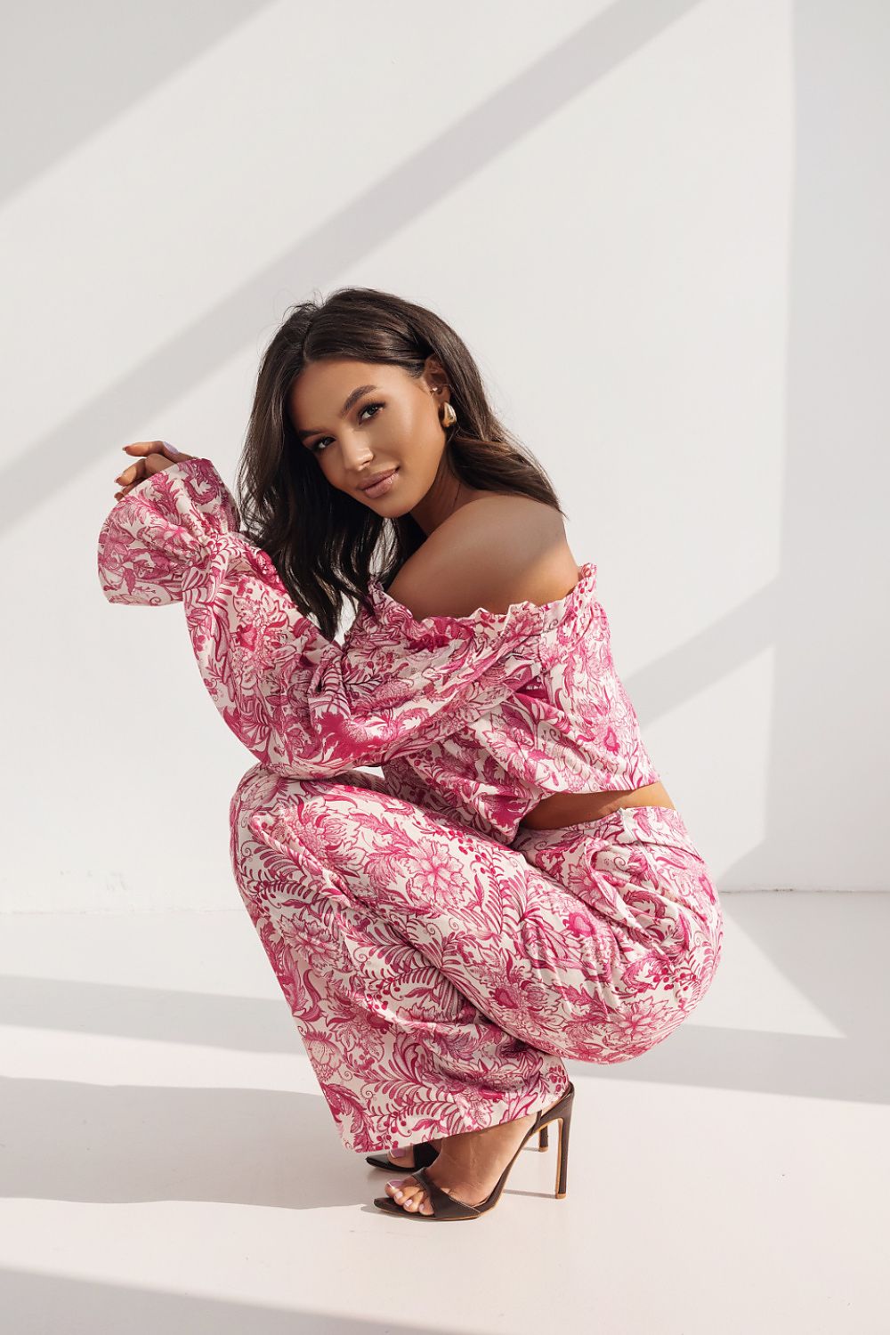 Chic women's ensemble by LaBalancia showcasing a cropped frilled top and wide-leg trousers in pink floral print, exuding feminine charm and sophistication.