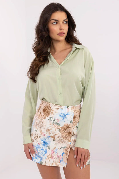 Sophisticated women's shirt by NM in soft green, featuring a fitted classic collar, paired with a floral mini skirt for a stylish ensemble.