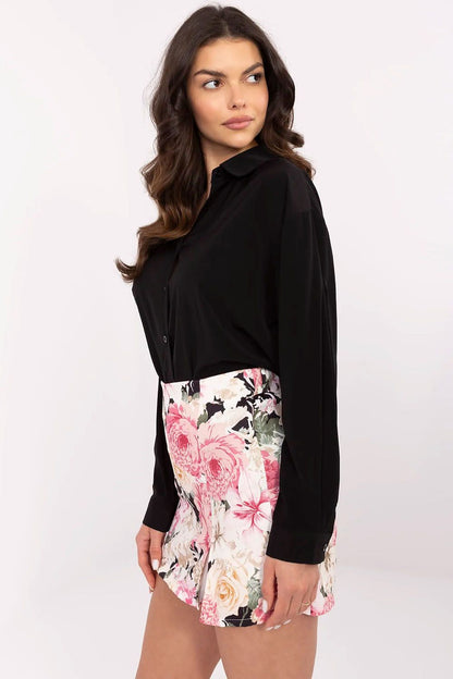 Side view of the luxurious long sleeve black women's shirt by NM, paired with a fashionable floral skirt.