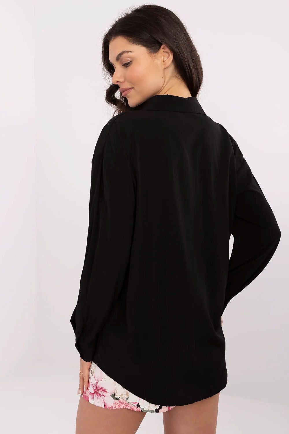 Back view of the sophisticated long sleeve women's shirt in black by NM, highlighting its stylish design paired with floral shorts.
