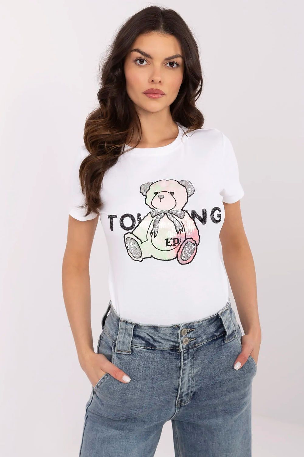 Sophisticated presentation of NM women's t-shirt with unique teddy bear artwork, model styled in chic trousers.