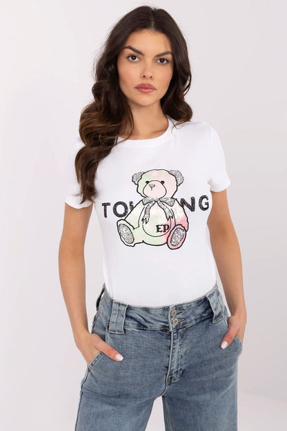 Sophisticated presentation of NM women's t-shirt with unique teddy bear artwork, model styled in chic trousers.
