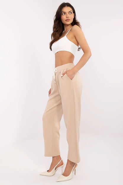 Elegant high waist tracksuit trousers for women by Italy Moda, styled with a cropped top and heels, showcasing a chic casual look in a soft beige colour, perfect for versatile styling.