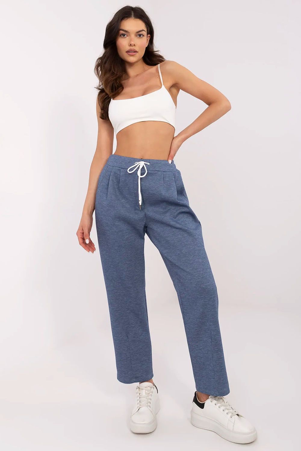 Elegantly styled high waist tracksuit trousers by Italy Moda, showcased with a fitted white top and white sneakers, emphasising comfort and sophistication for women.
