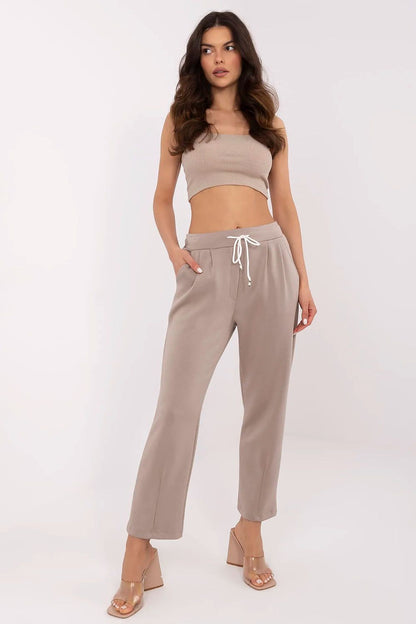 Chic high waist tracksuit trousers by Italy Moda in a warm neutral tone, paired with a cropped top and transparent heels, exuding a luxurious casual vibe.