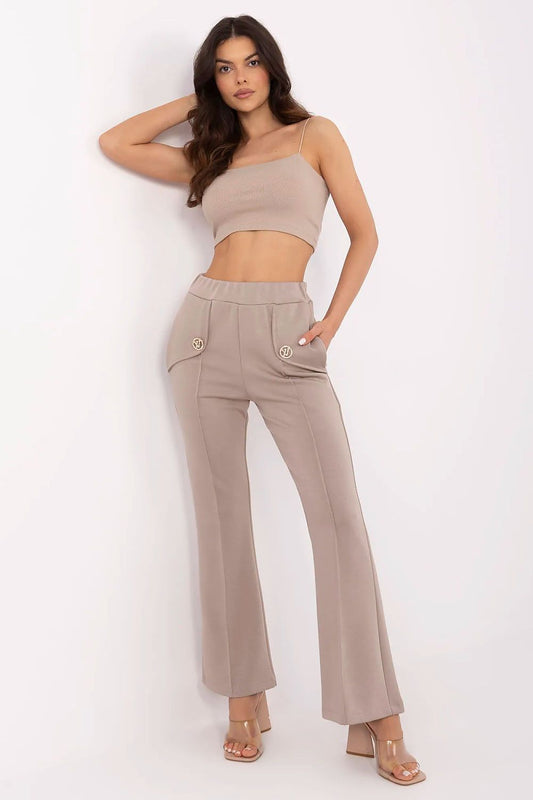 Elegant model showcasing Italy Moda high waist bell-shaped sweatpants in a sophisticated neutral tone, featuring side pockets and detachable brooches, ideal for a stylish casual look.