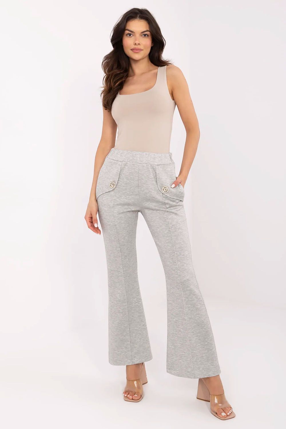 Stylish woman dressed in Italy Moda high waist bell-shaped sweatpants in light grey, complemented by a beige bodysuit and elegant heels, showcasing a refined and contemporary design.