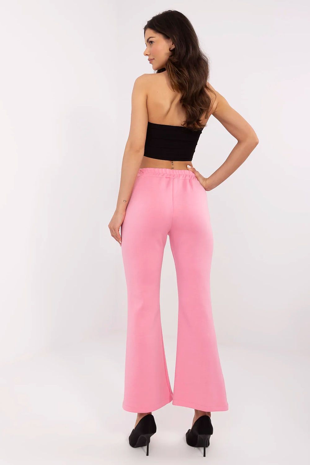 Refined back view of Italy Moda high waist bell-shaped sweatpants in pink, featuring a comfortable elastic waistband and a flattering fit, styled with a black cropped top and chic heels.