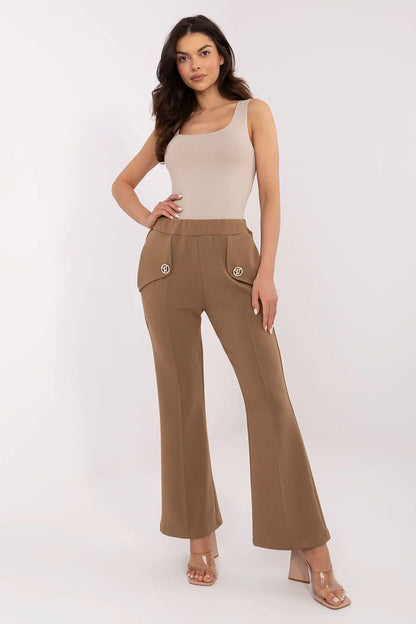 Elegant woman wearing Italy Moda high waist bell-shaped sweatpants in a rich brown colour, paired with a fitted top, showcasing the stylish side pockets and flattering silhouette.