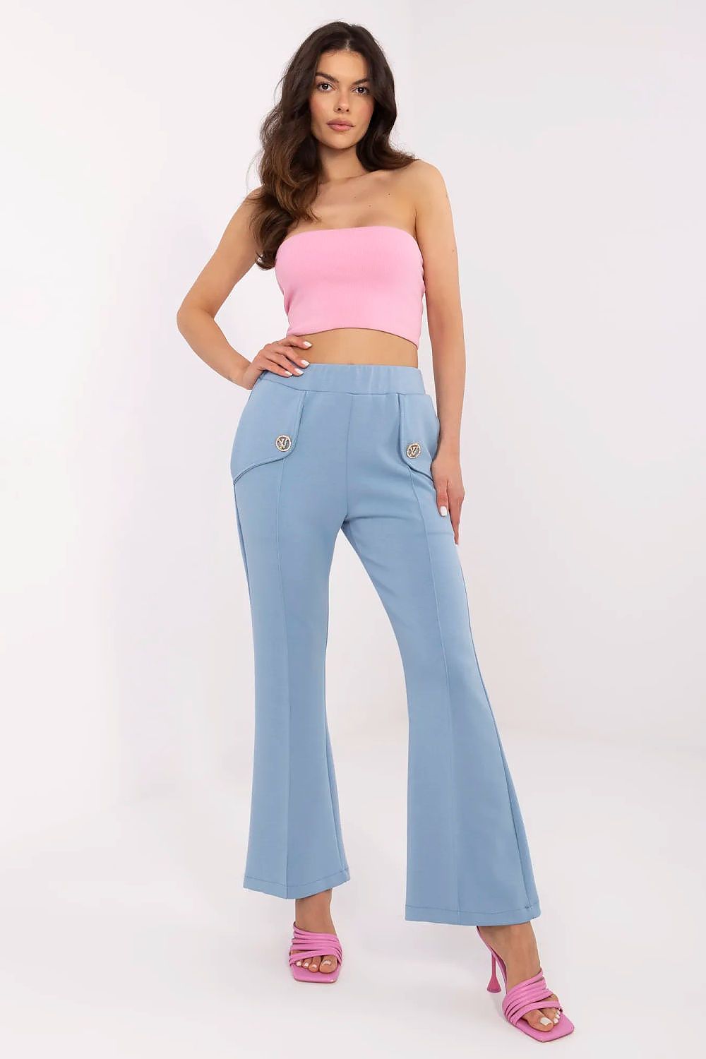 Trendy woman dressed in Italy Moda high waist bell-shaped sweatpants in soft blue, complemented by a stylish pink crop top, exemplifying modern elegance.