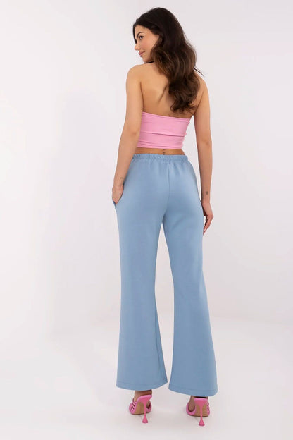 Elegant high waist bell-shaped sweatpants by Italy Moda, showcased from the back, featuring a light blue hue, paired with a chic pink crop top.