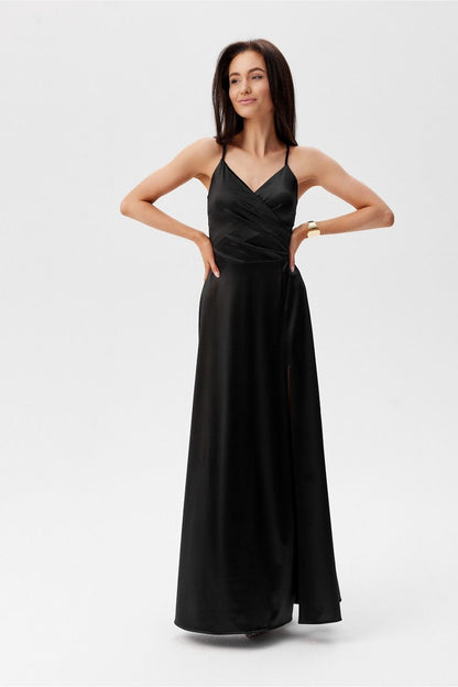 Chic black maxi dress with a slit by Roco Fashion, designed with thin straps and a flattering silhouette for upscale events.