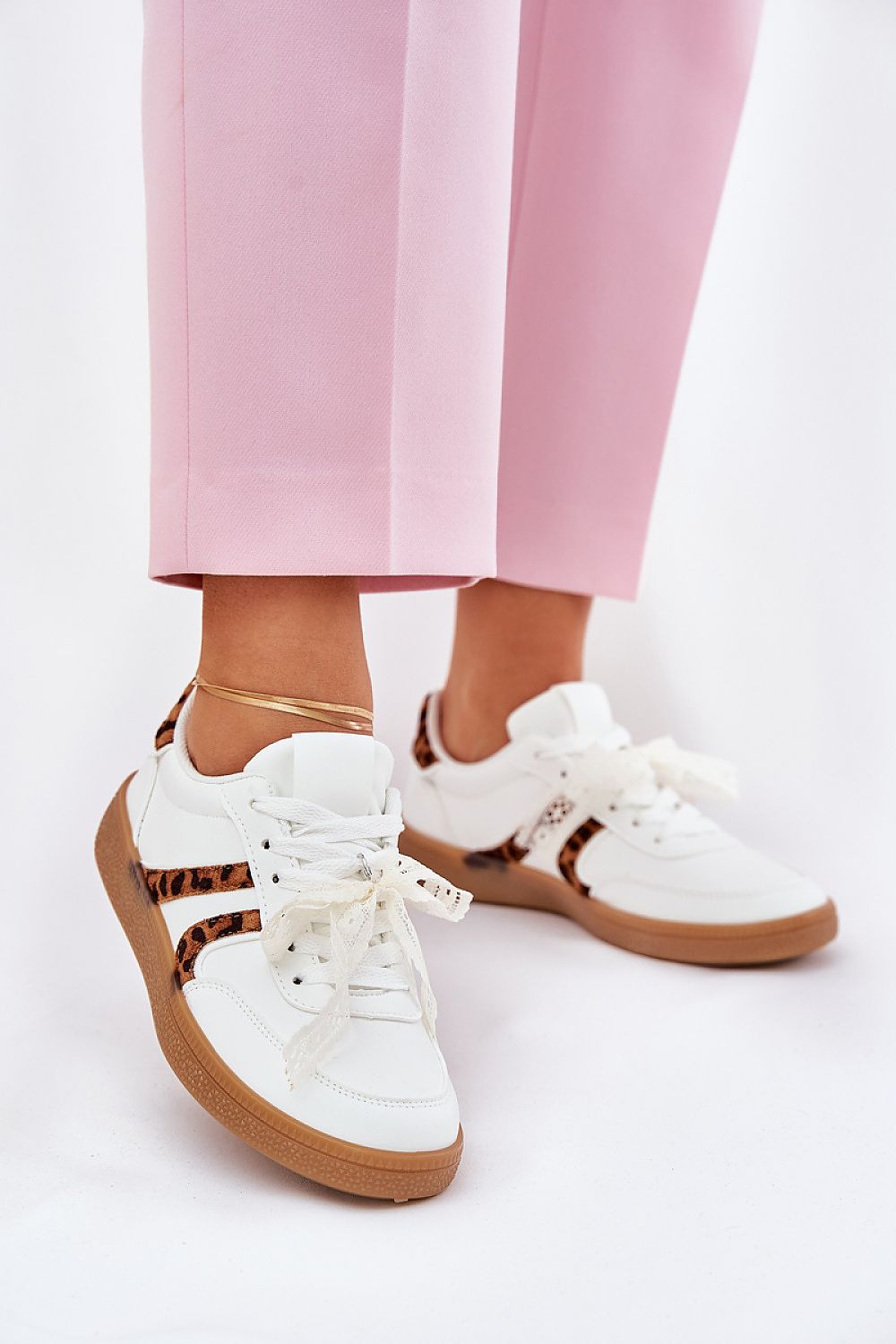 Chic white and leopard print sneakers for women, featuring stylish lace ties and a low silhouette, elegantly worn with pink trousers by Step in Style.