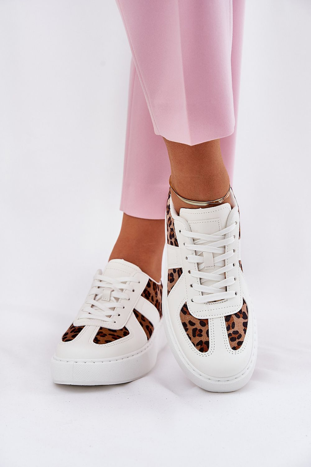 Elegant white leather and leopard print women's sneakers from Step in style, paired with pink trousers, ideal for a chic casual look.