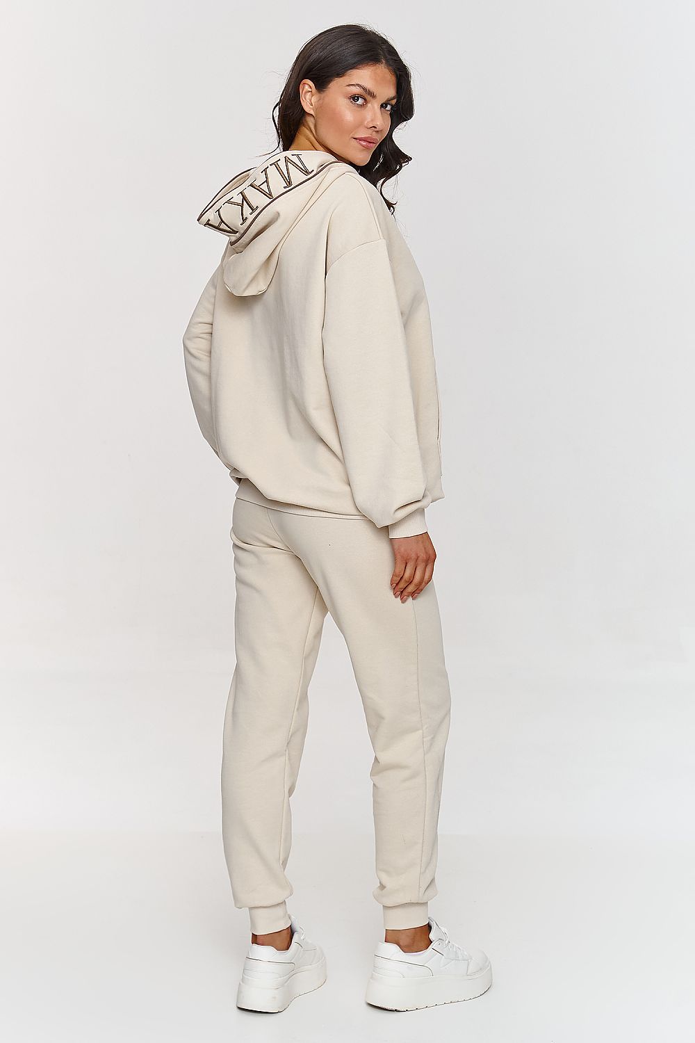 Detailed display of pockets on the Makadamia elegant hoodie and pants set, combining practicality with sophisticated design.