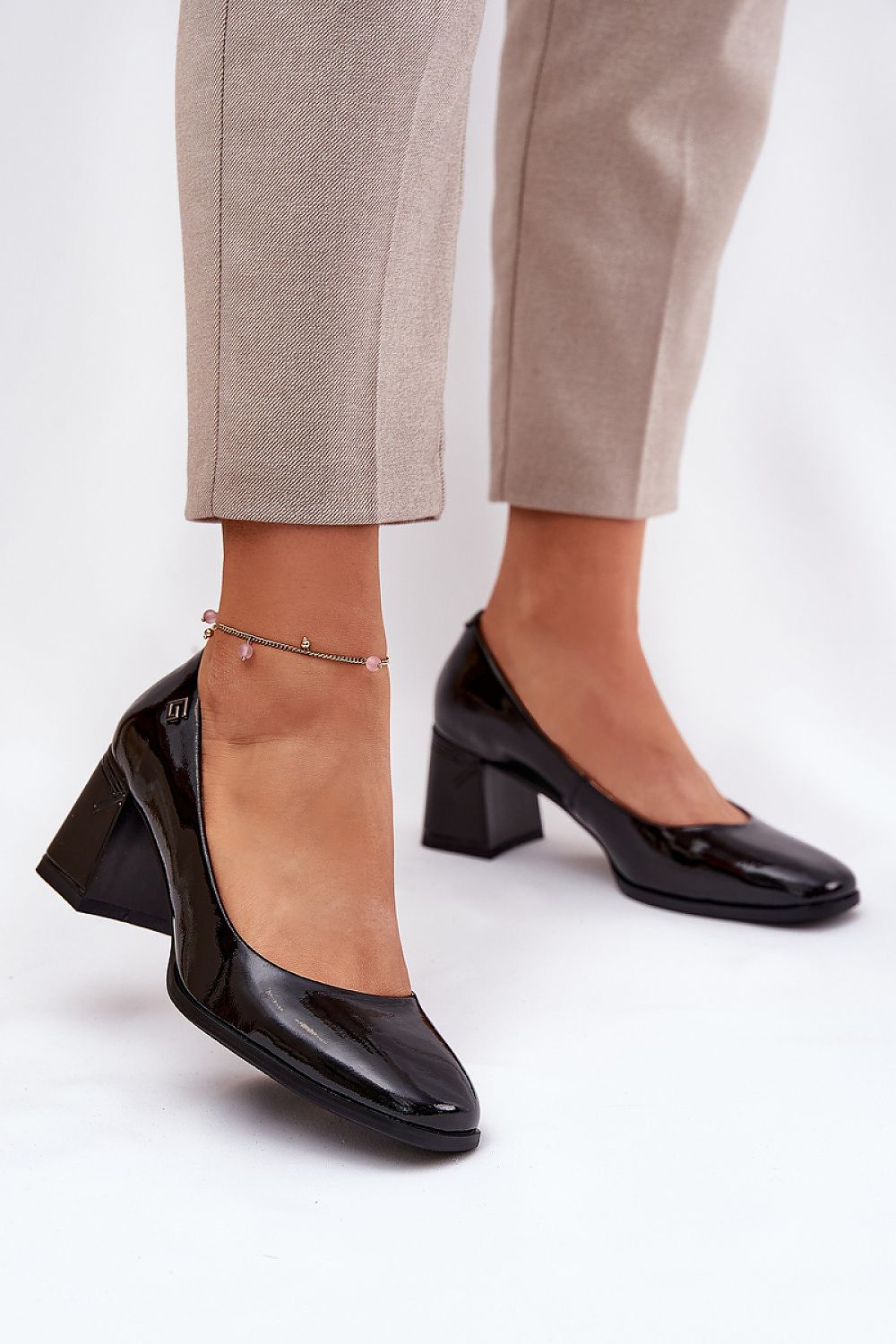 Chic black natural patent leather block heel pumps for women by Step in Style, elegantly styled with fitted trousers for a refined appearance.