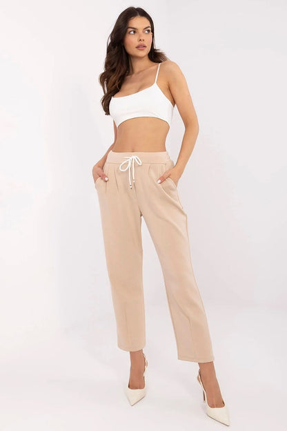 Chic beige sweatpants by Italy Moda, featuring a high waist and pockets, styled casually with a white crop top.