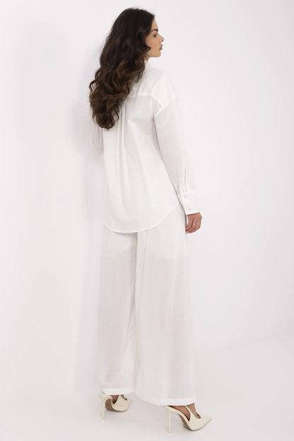 Back view of a luxurious women's cotton-linen outfit in white, showcasing a long sleeve top paired with high-waisted trousers, designed by NM.