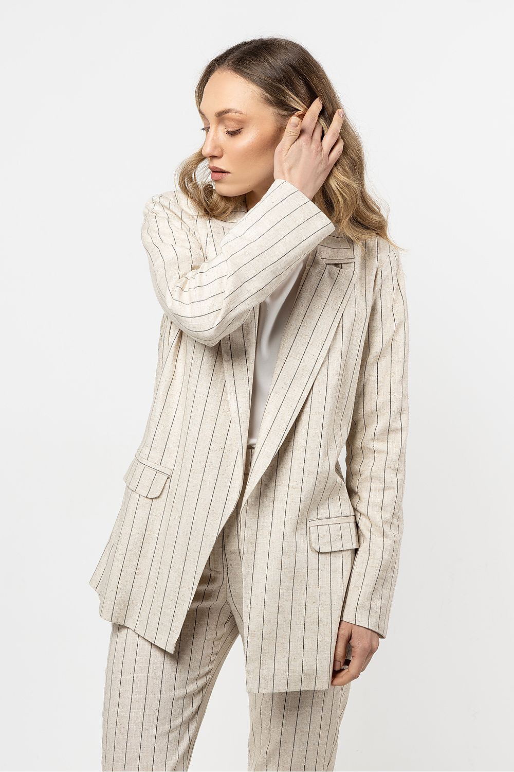 Detailed view of the linen blazer by Awama, highlighting the delicate stripe pattern and lightweight fabric, perfect for upscale occasions.