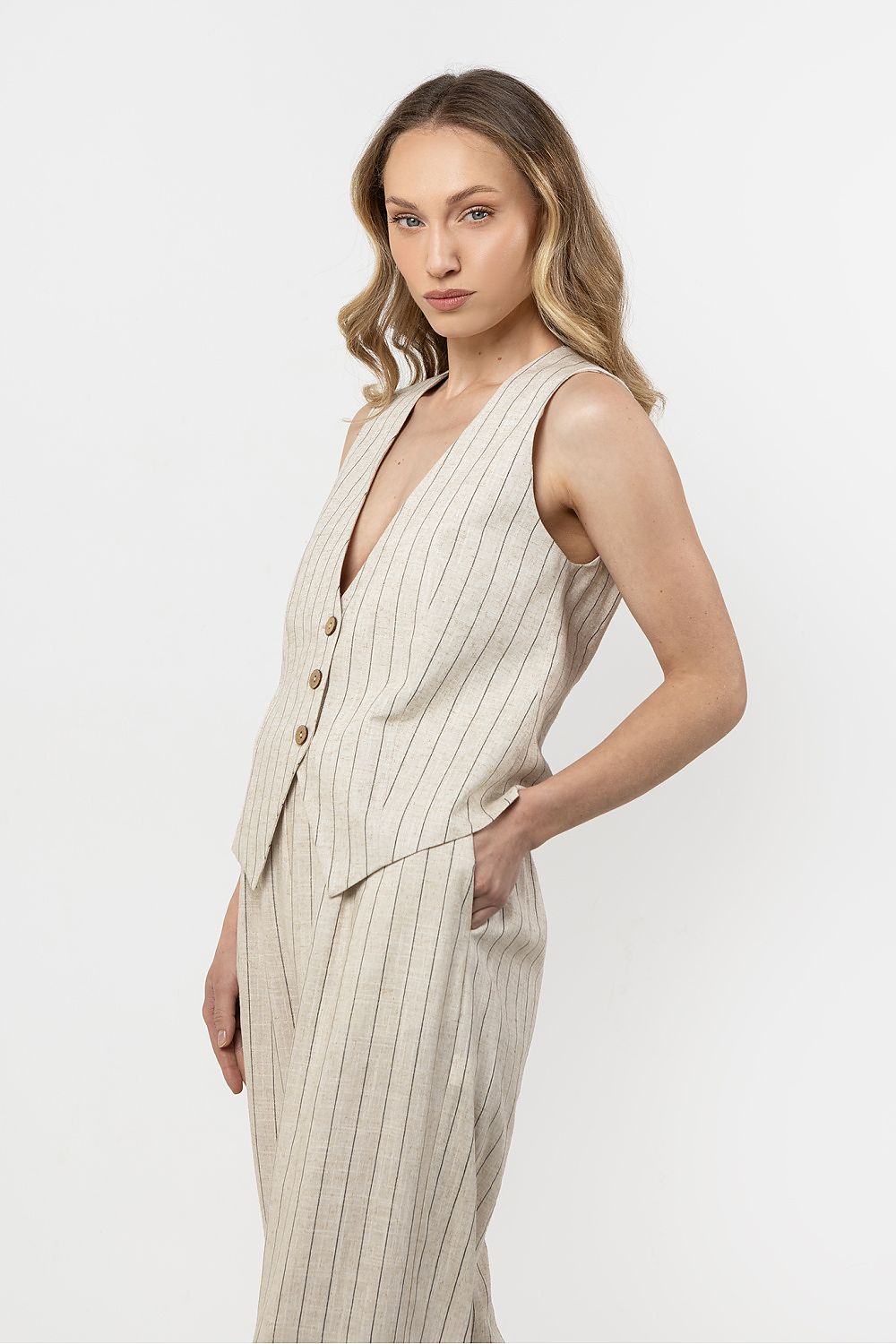 Sophisticated styling of Awama's linen vest on a fashion model, highlighting the versatile elegance of the short cut and V-neck.