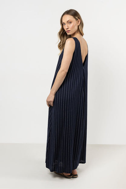 Model showcasing the flowing trapeze cut of awama's elegant linen maxi dress, perfect for warm weather.