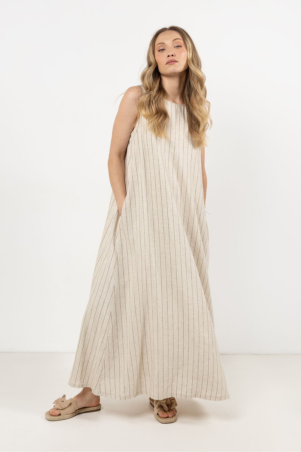 Side view of the stylish V-shaped open back of awama's loose linen maxi dress, highlighting sensuality.