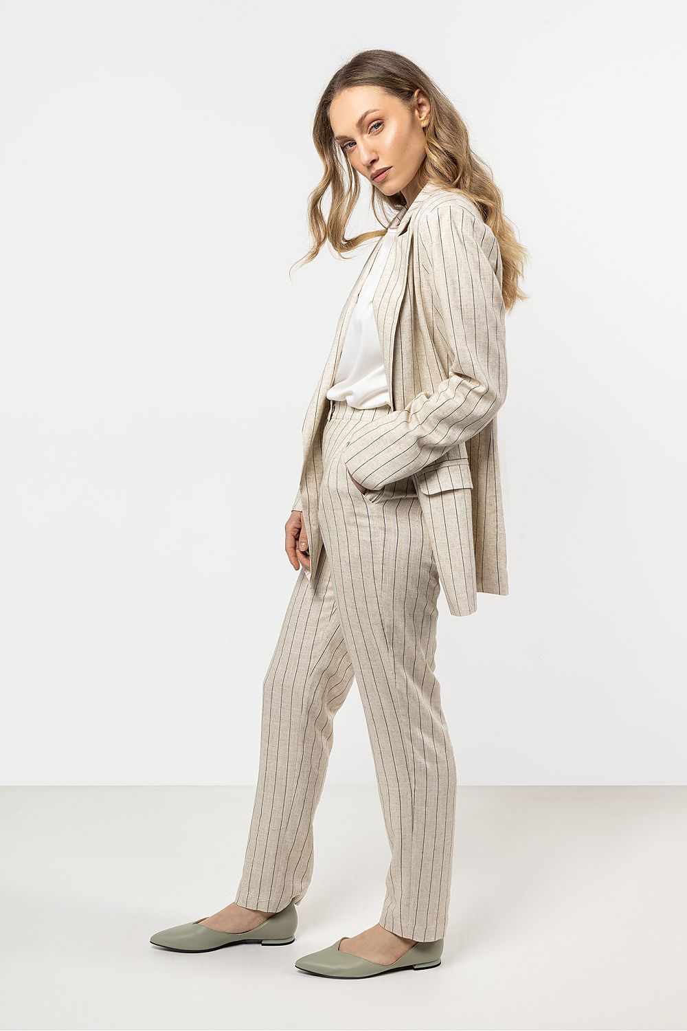 Fashionable model wearing Awama's elegant linen cigarette trousers, demonstrating style versatility from day to night.