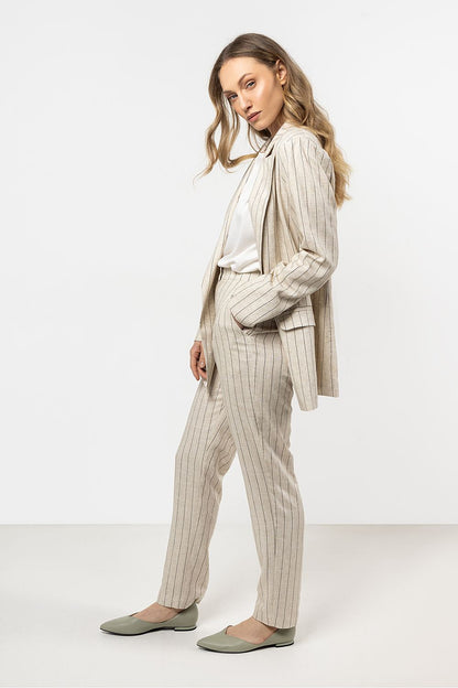 Fashionable model wearing Awama's elegant linen cigarette trousers, demonstrating style versatility from day to night.