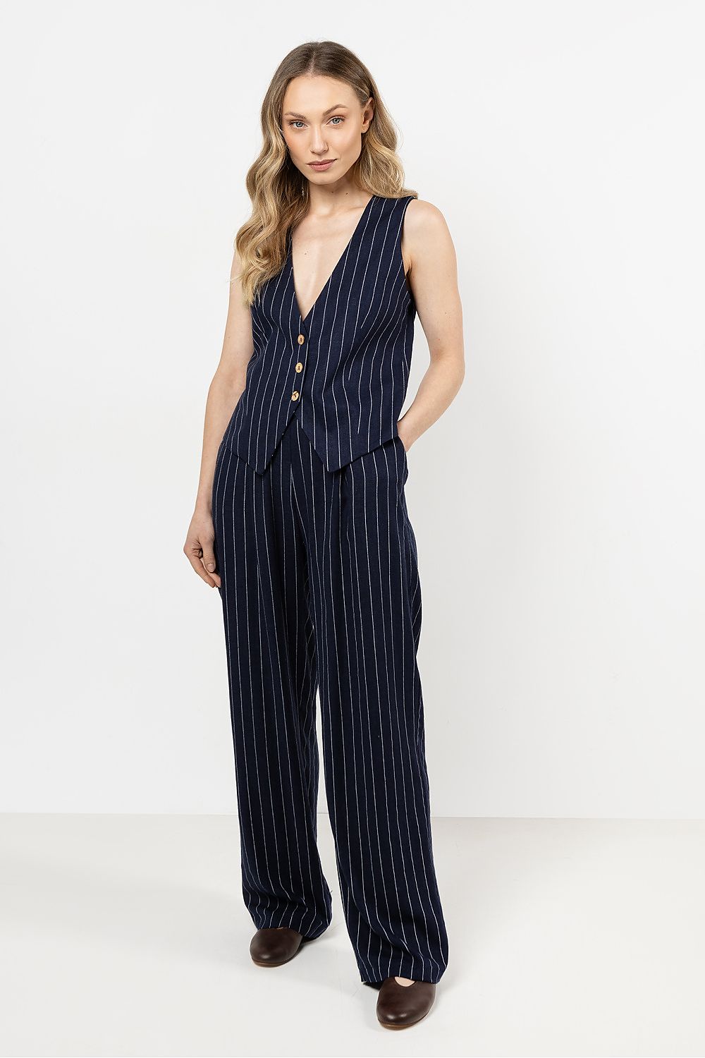 Elegant linen trousers by Awama featuring wide legs and thin stripes, available in sizes S to XL, perfect for a sophisticated summer look.